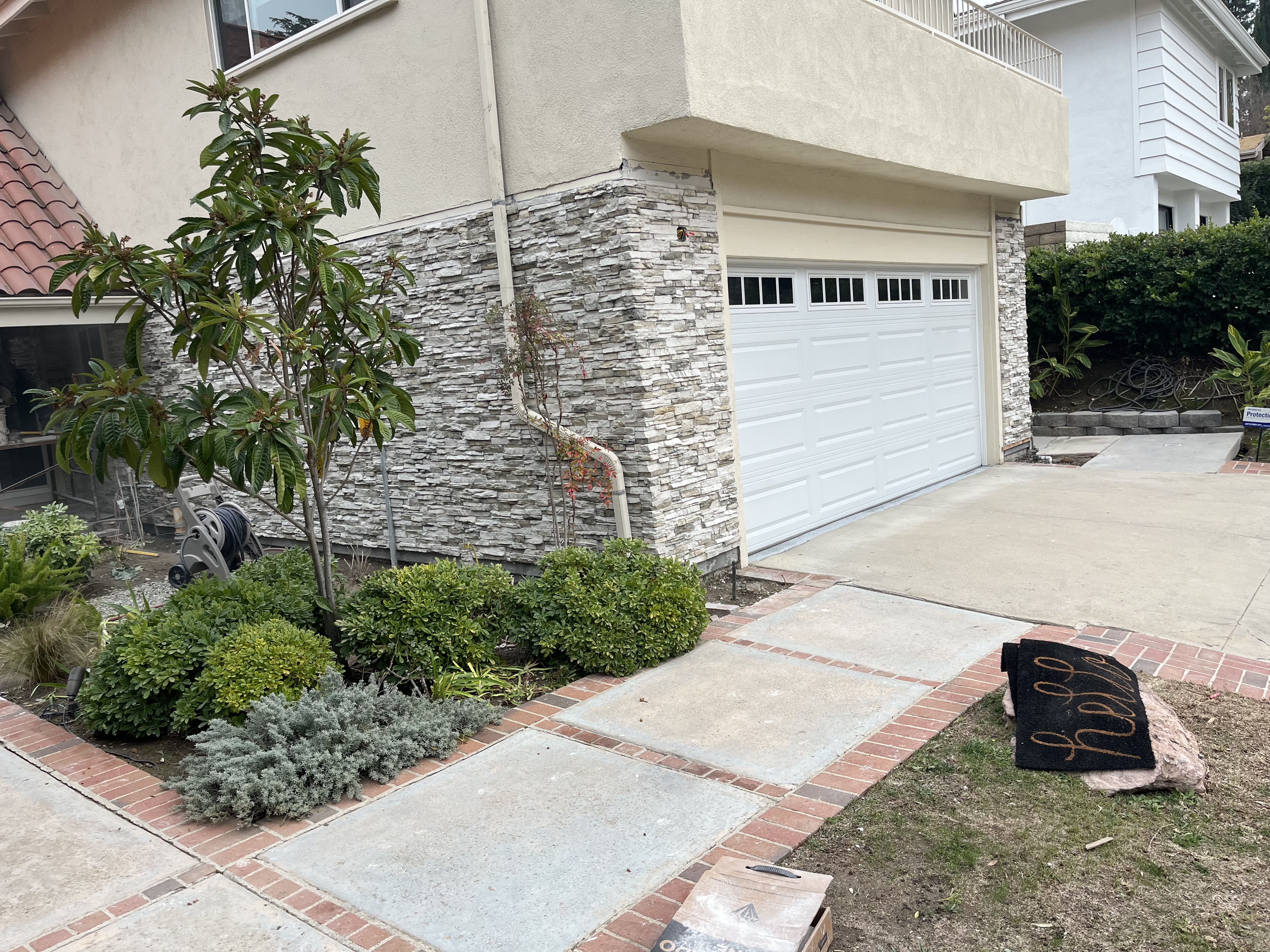 Stamped wood plank and smooth concrete courtyard driveway