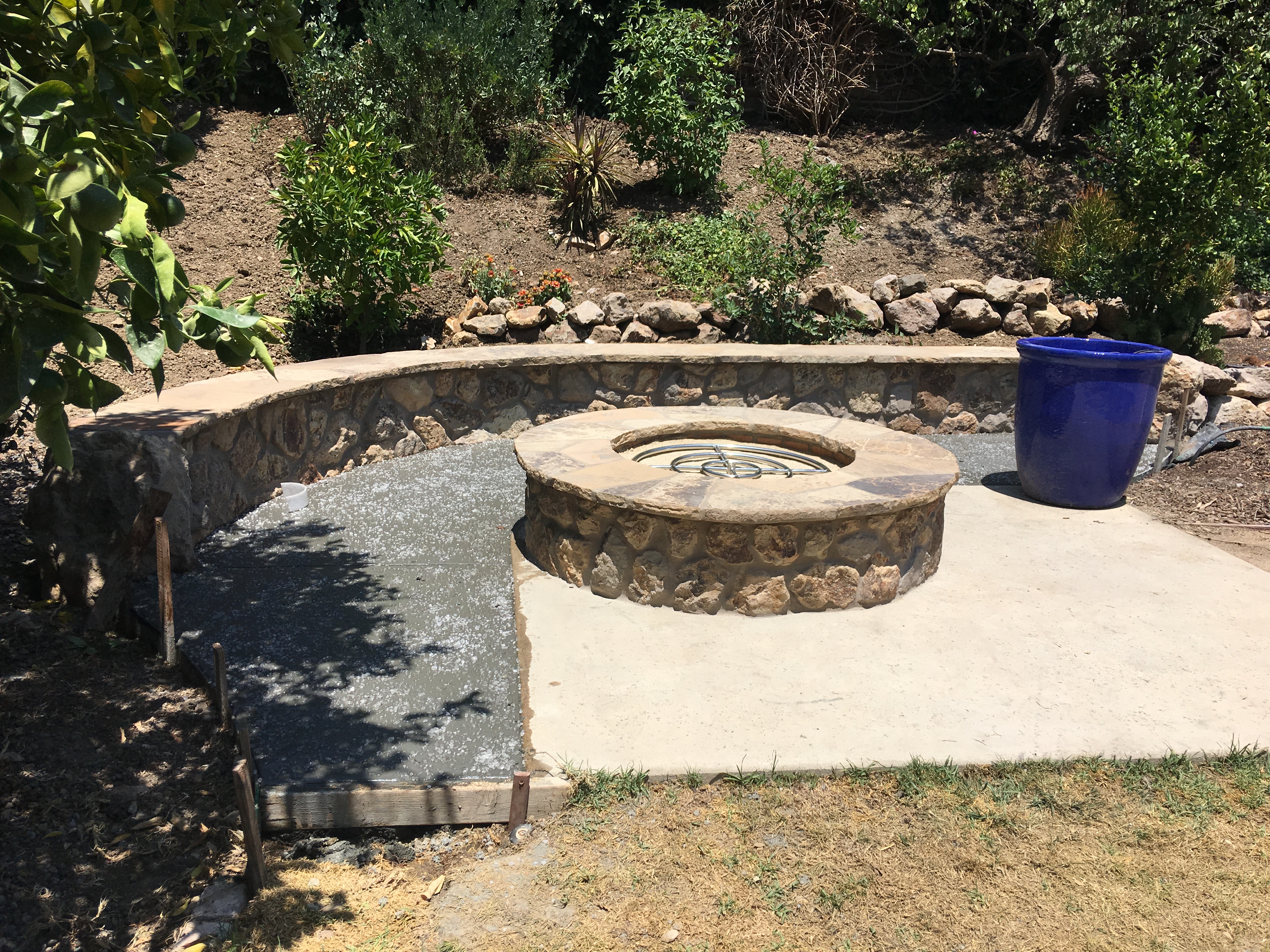 Stone fire pit with curved seating wall