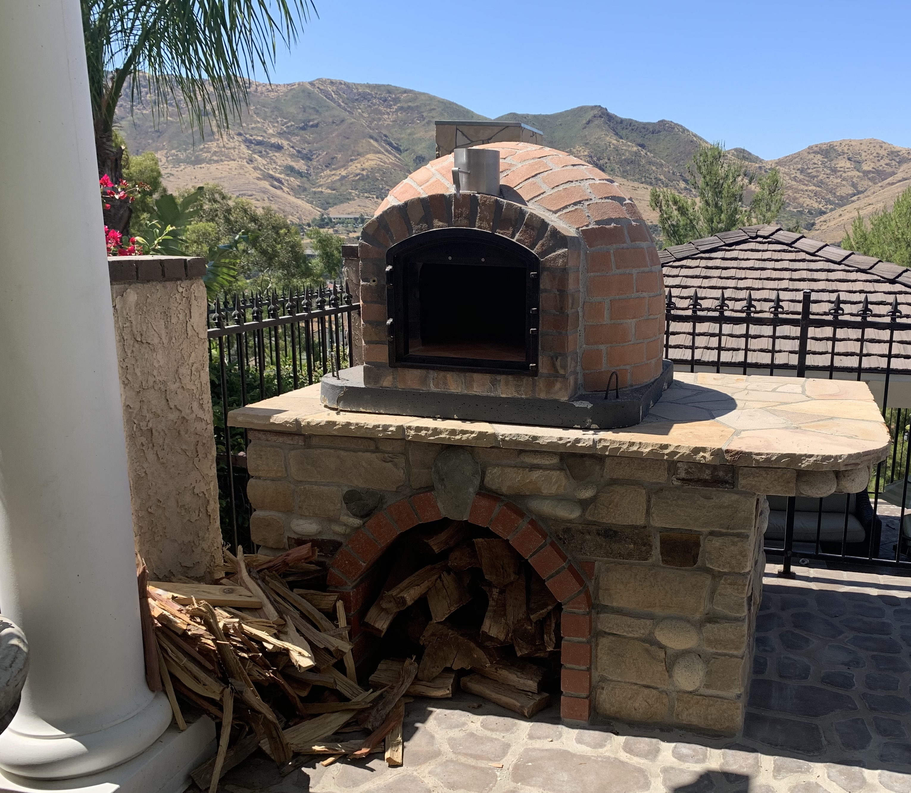 Outdoor pizza oven with stone base and mountain views
