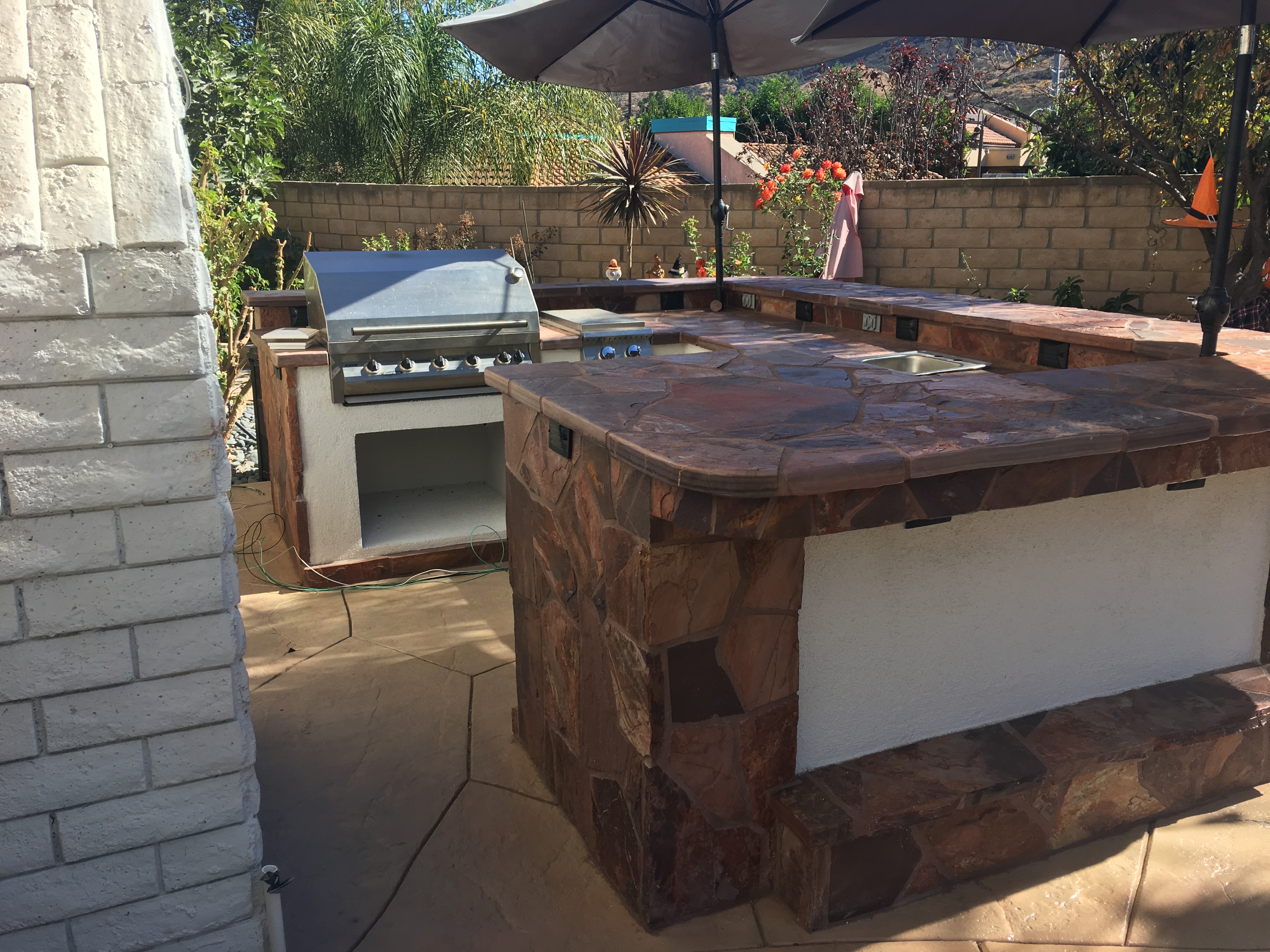 Outdoor kitchen with flagstone countertop and built-in grill