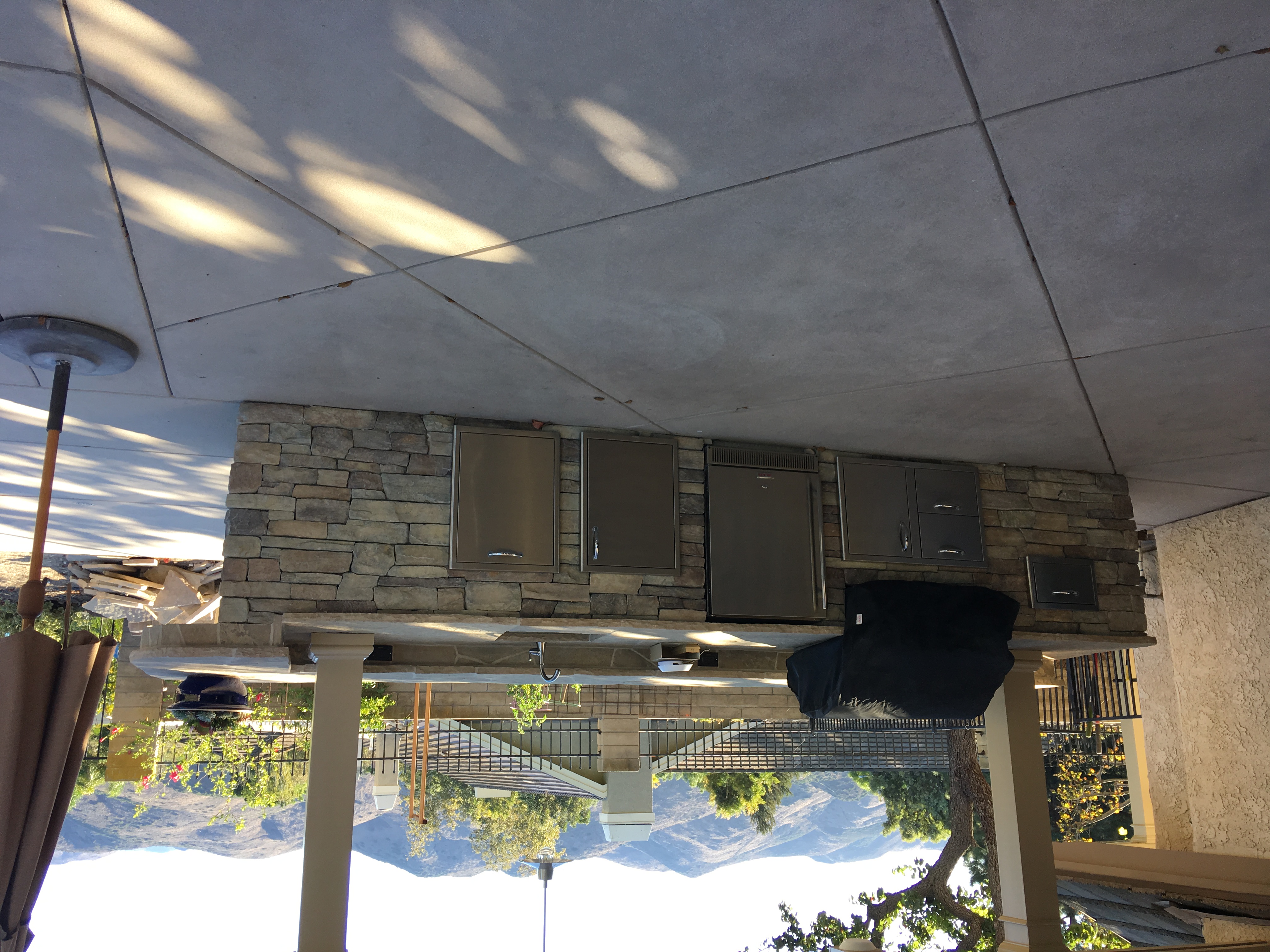 Outdoor kitchen with stone veneer and stainless appliances